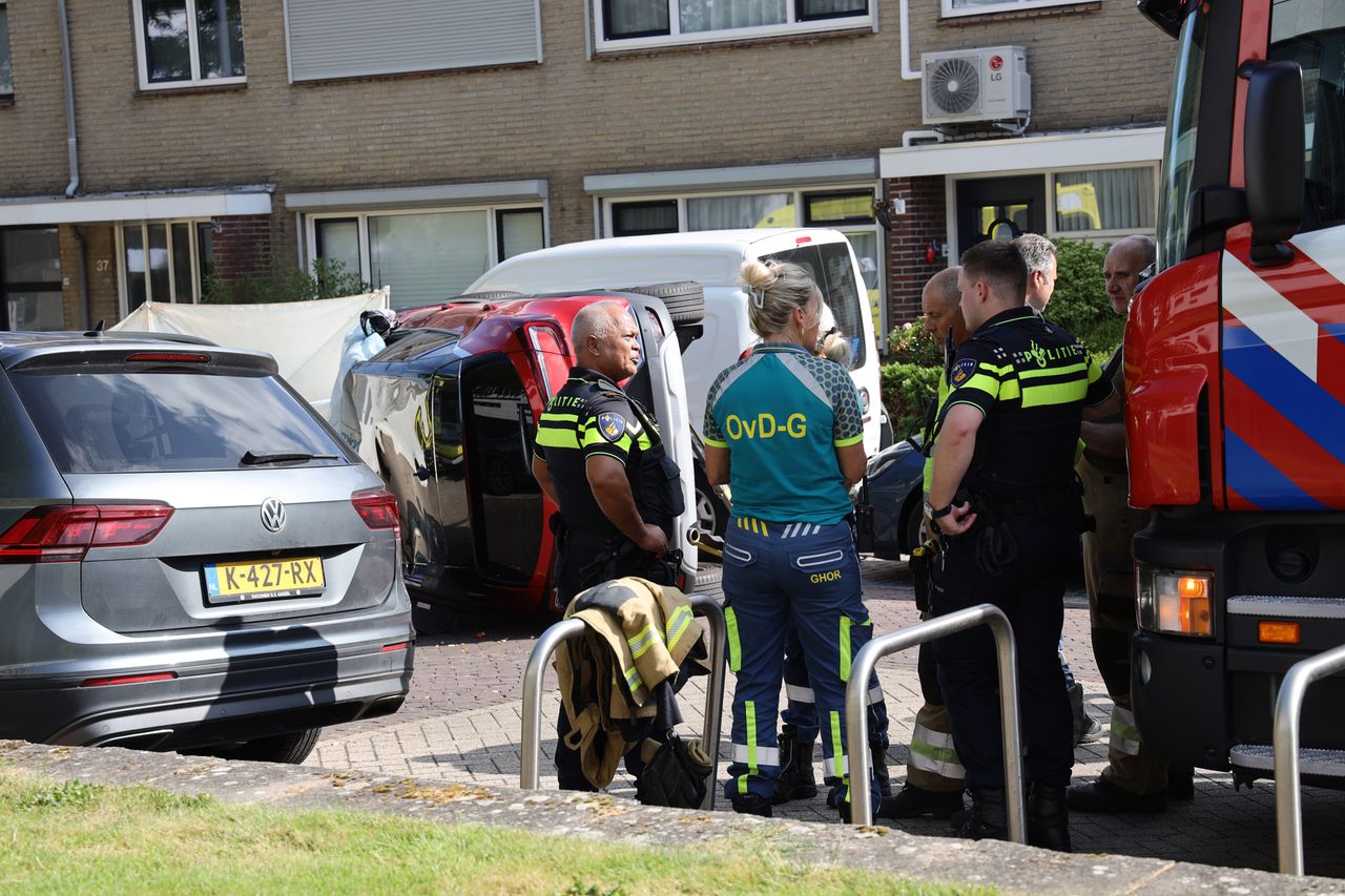 De man raakte met zijn auto een aantal geparkeerde auto's en sloeg daarna met zijn auto om (foto: Marco van den Broek/SQ Vision).