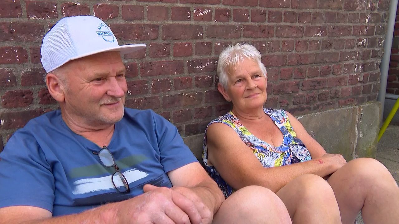 Tegen een muurtje wacht Ans en haar man op de eerste wagens (foto: Imke van de Laar)