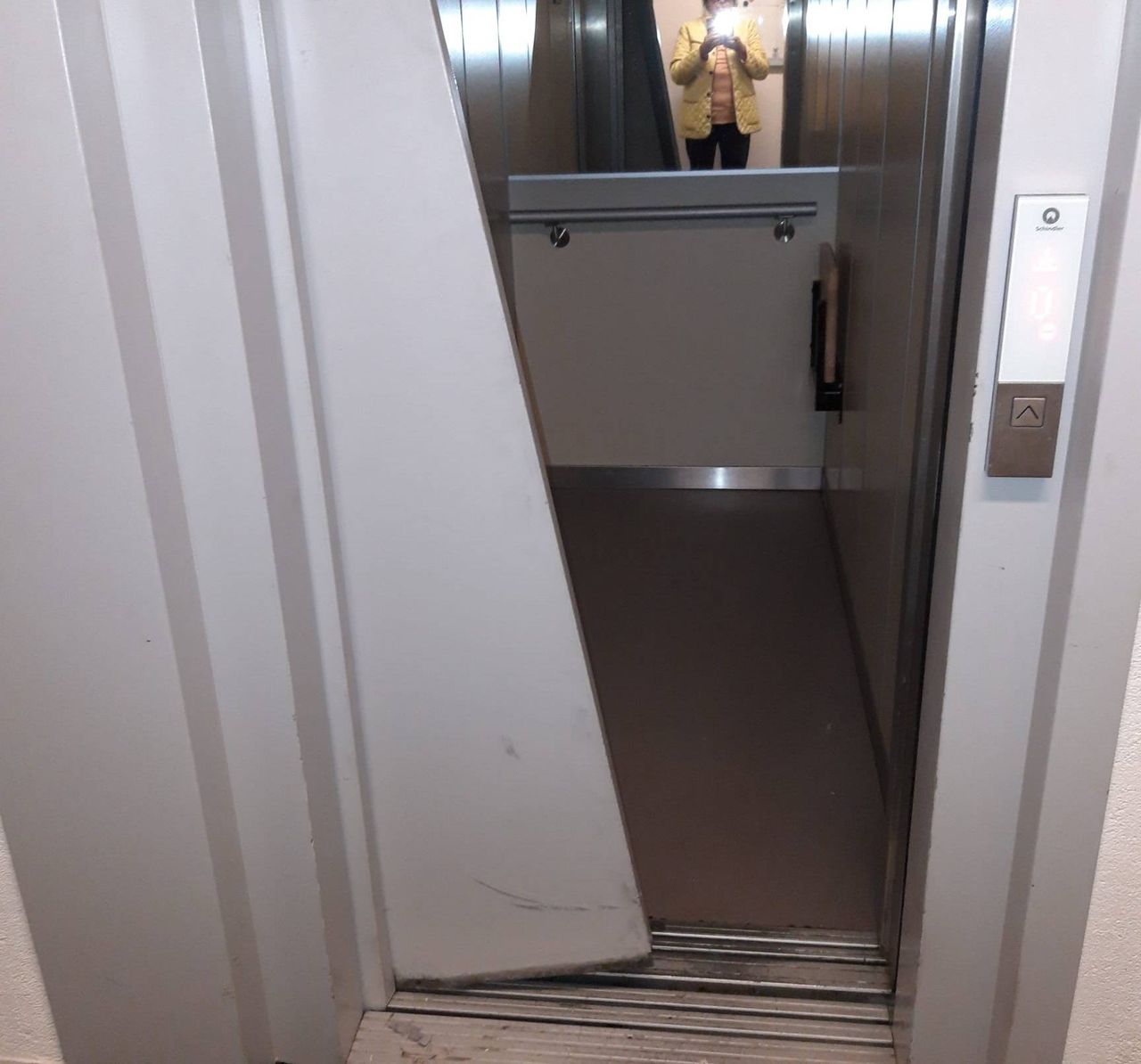 De deur van de lift zit helemaal scheef.