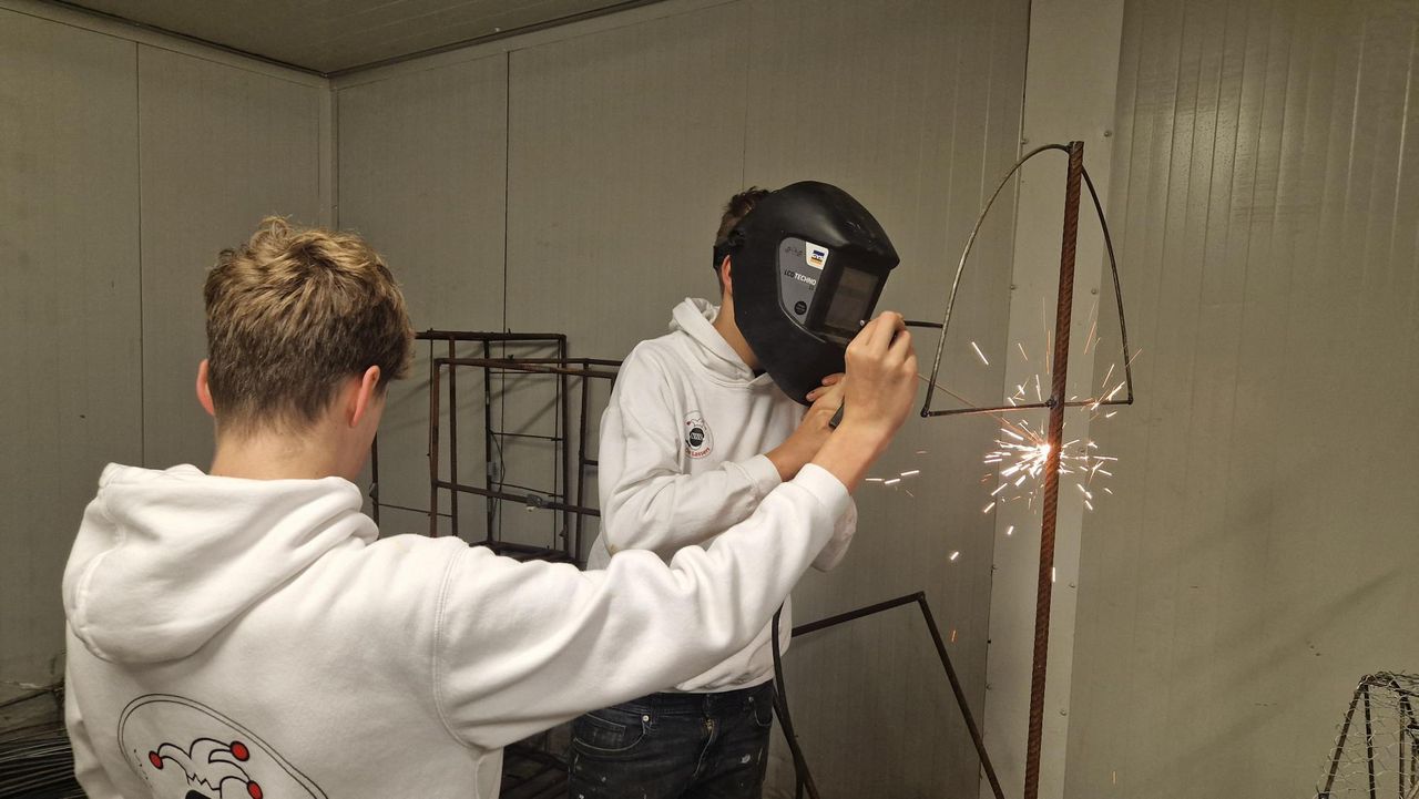 Tim (13) en Luca (14) aan het lassen aan hun carnavalswagen