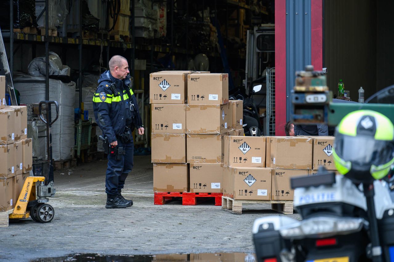 De politie bij meerdere pallets met dozen waarin accu's zitten (foto: SQ Vision).