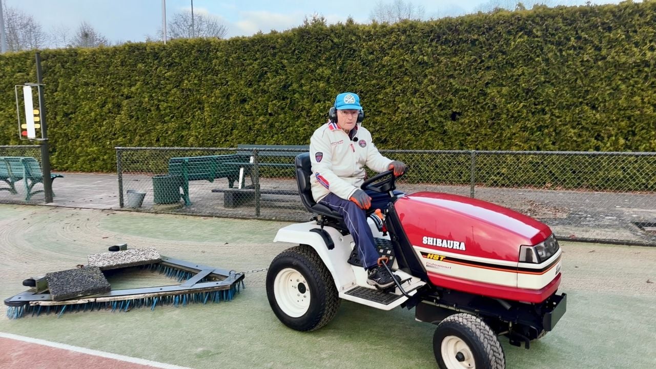 Jacques borstelt de tennisbaan schoon (foto: Jan Peels).