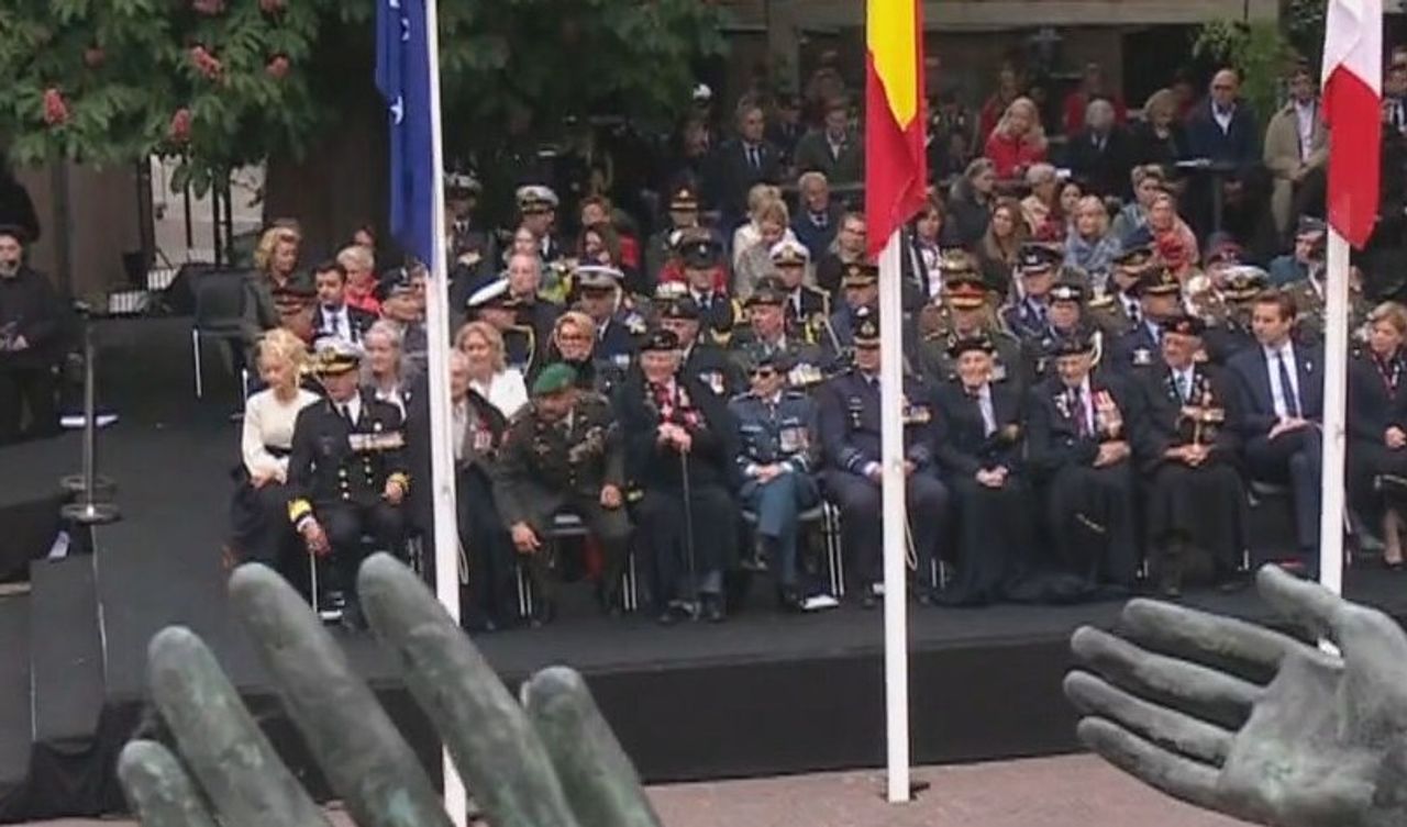 Marco Kroon springt als eerste op als de demonstrant de viering verstoort. 