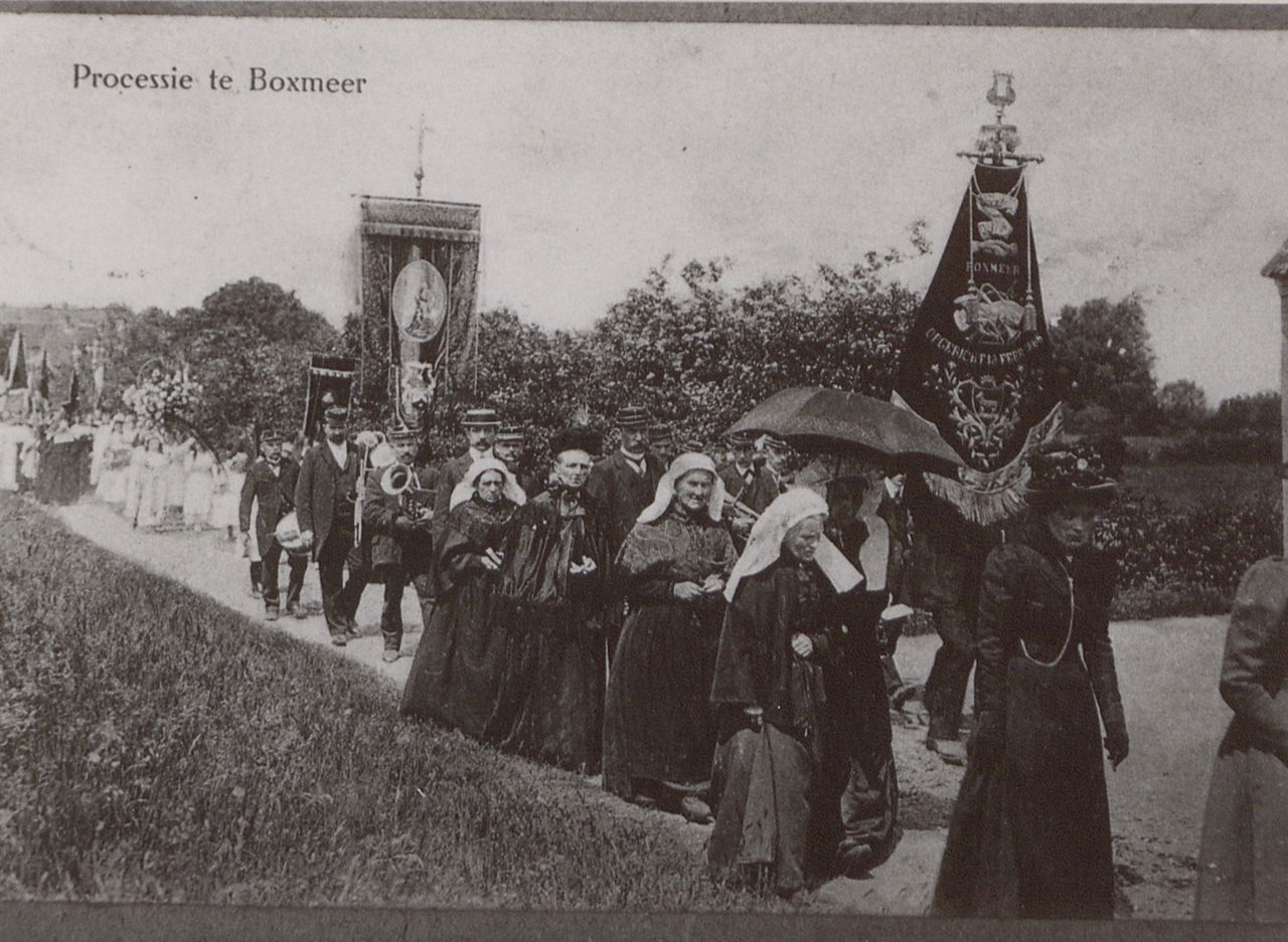 Een processie trekt door de Boxmeerse velden in de volle zon. Voorop dames in het lang en met Brabantse mutsen, vervolgens Utile Dulci met het vaandel en dan bruidjes en de rest van de stoet.  (foto: BHIC)