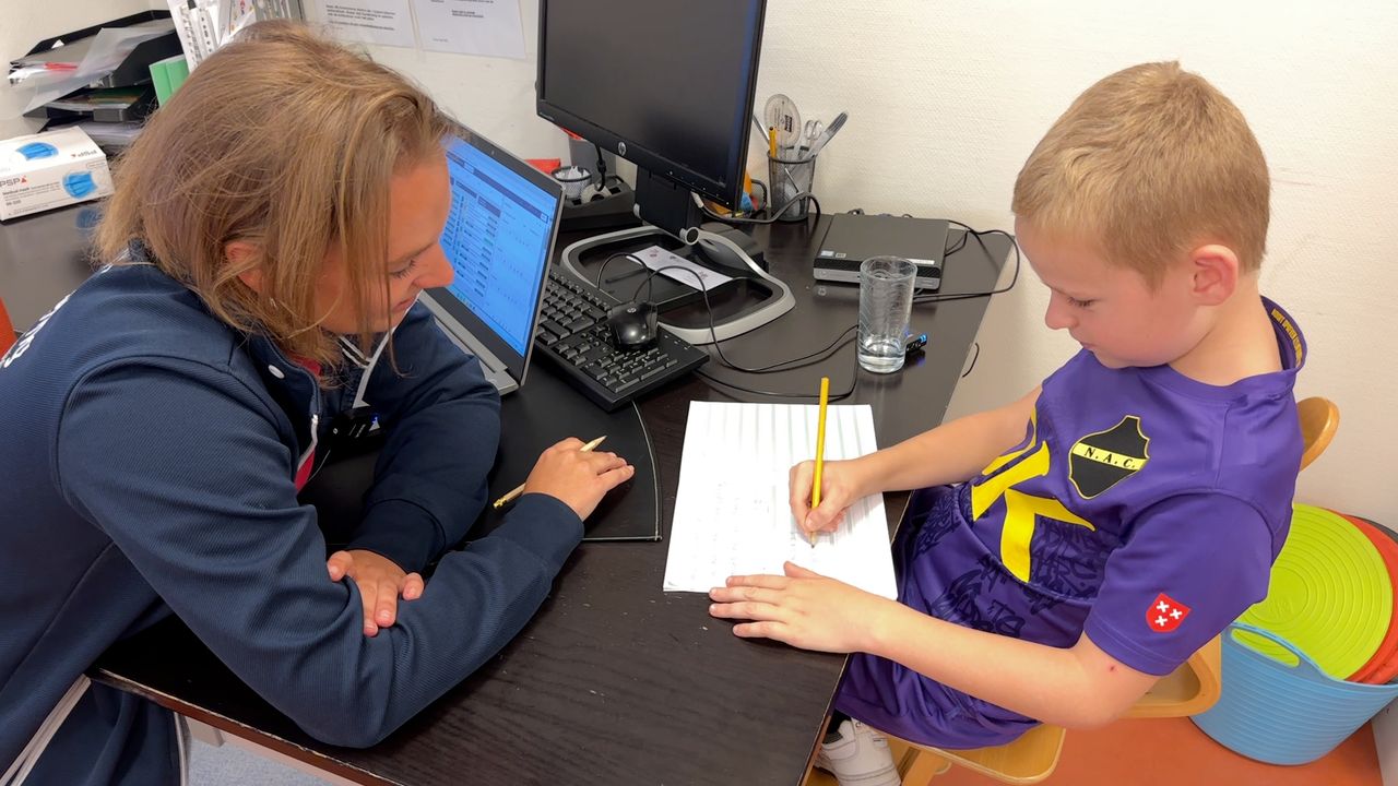 Kinderfysiotherapeut Isabelle Kranenburg doet een schrijfoefening met Mike (foto: Ronald Sträter).