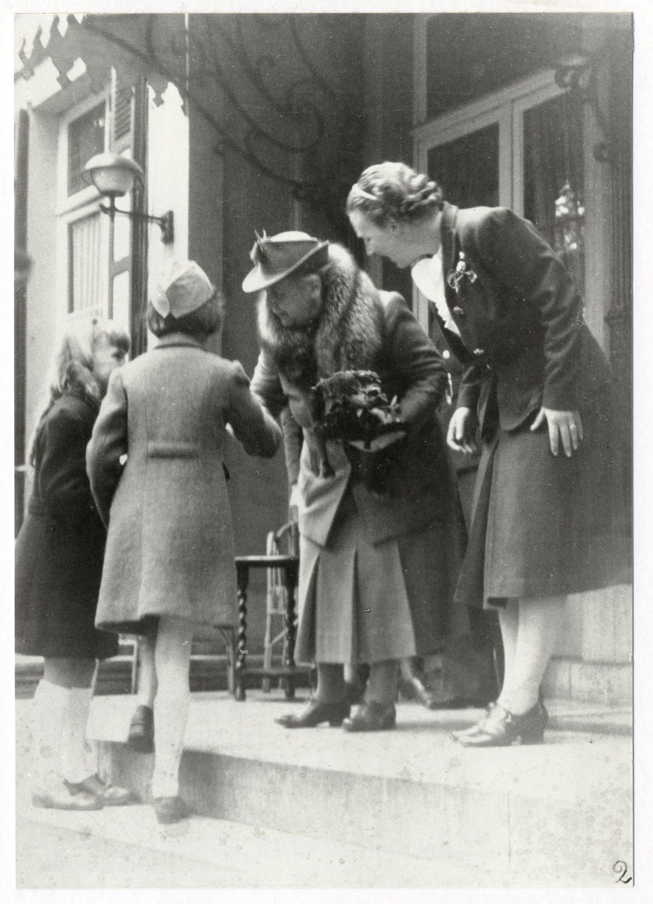 Twee meisjes bieden koningin Wilhelmina en prinses Juliana bloemen aan op het bordes van Anneville (foto: Foto Atelier Boogaard Breda/Stadsarchief Breda).
