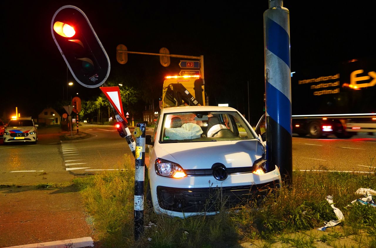 De auto tussen de lantaarnpaal en het verkeerslicht in (Foto: Persbureau Heitink/ Bart Meesters.)