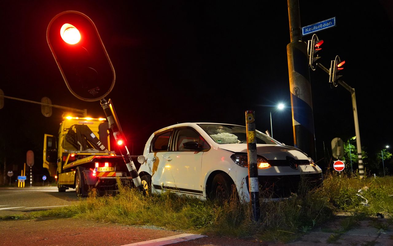 De auto tussen de lantaarnpaal en het verkeerslicht in (Foto: Persbureau Heitink/ Bart Meesters.)