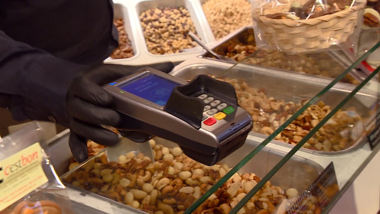 De winkelier draagt handschoenen. 