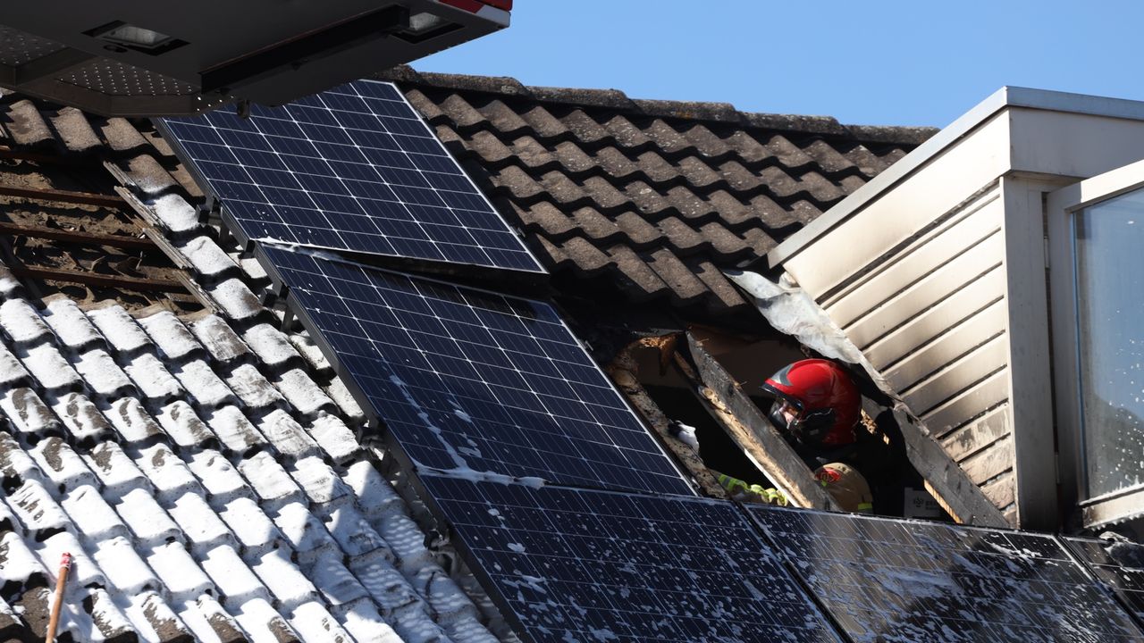 Een brandweerman controleert het dak. (Foto: Sander van Gils / SQ Vision)