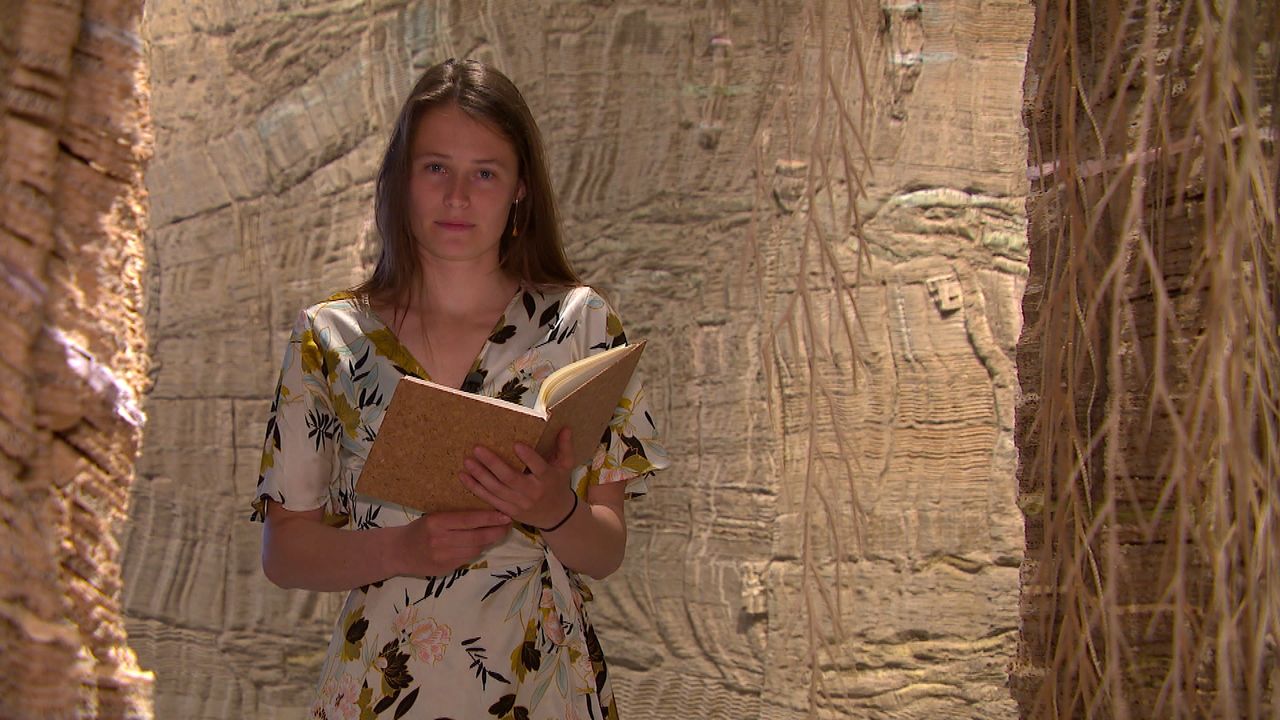 Charlotte draagt haar gedicht voor tussen de kunstwerken van Eva Jospin. 