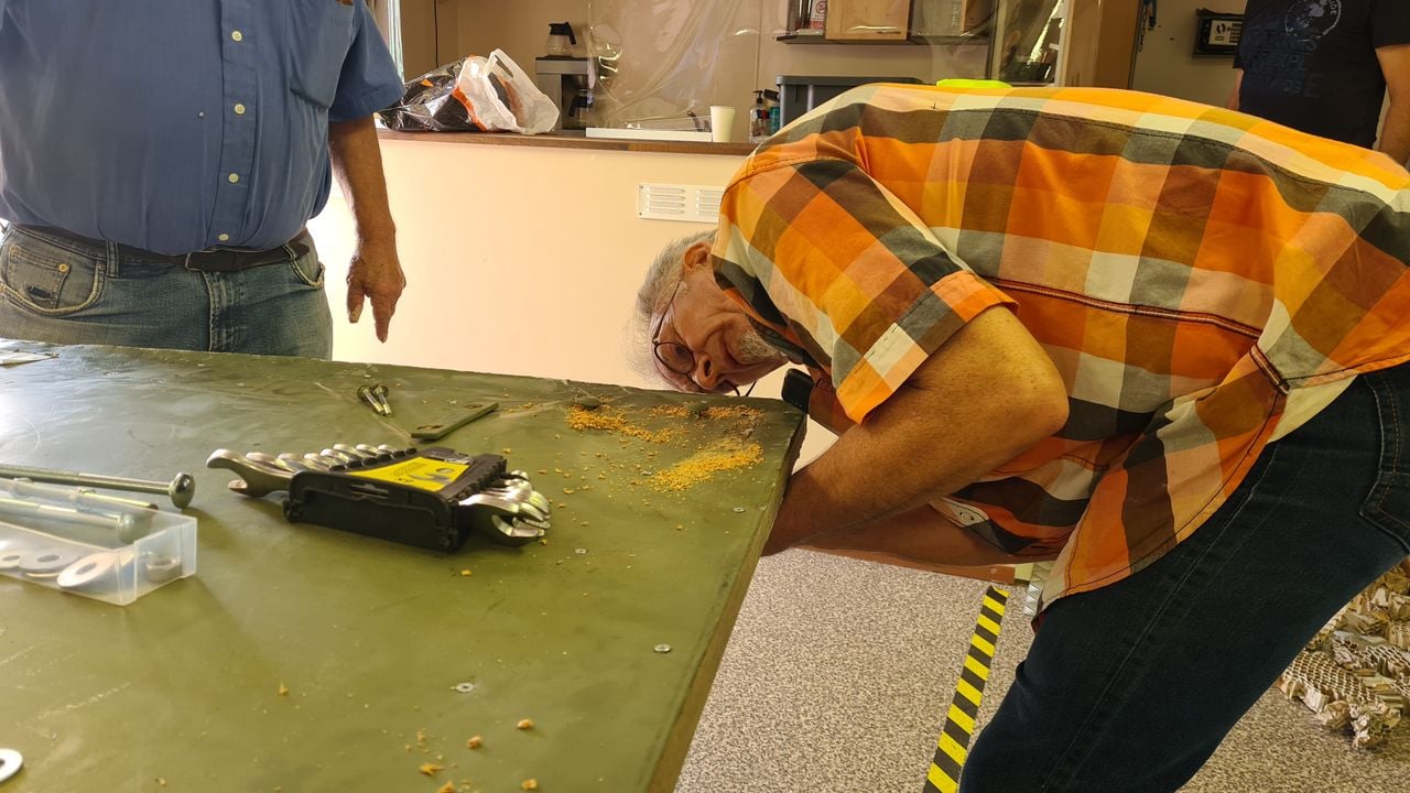 De beschadigde deur wordt gerepareerd door secretaris Avezaath (Foto: Noel van Hooft).