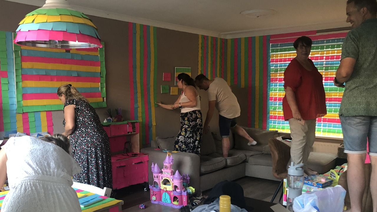 Groep vrienden plakt Post-its in het huis van Anne en Bas (foto: Elsbeth Stolzenbach)