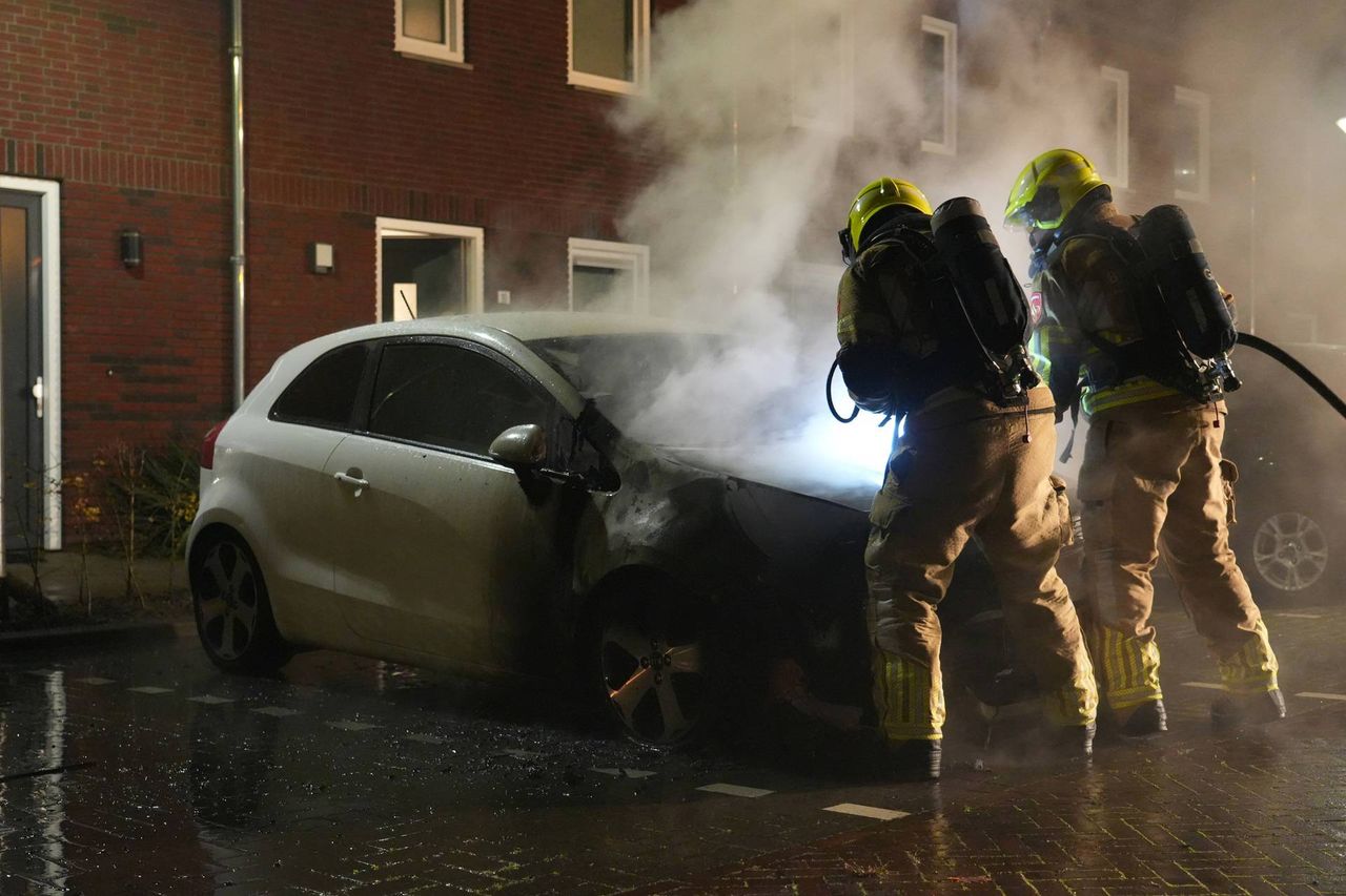 Brandweerlieden blussen de auto in Rijen. (Foto: Jeroen Stuve/Persbureau Heitink..)