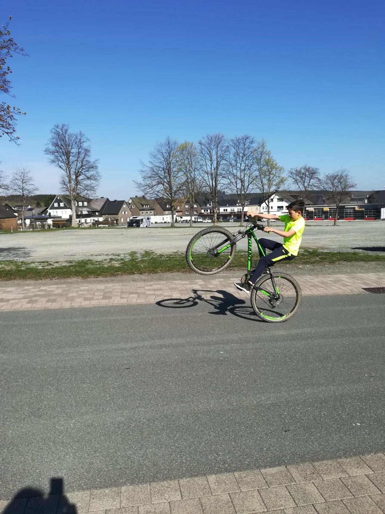 Jasper als klein mannetje terwijl hij wheelie's maakt door de straat.