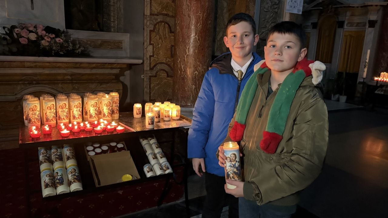 Max (11) en Thijs (12) steken allebei een kaarsje aan voor hun oma, die overleed aan de gevolgen van kanker (foto: Imke van de Laar.)