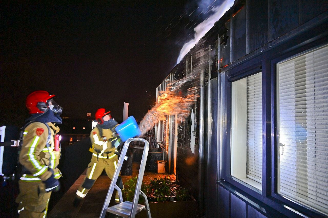 De brandweer bluste het vuur eerst met emmers water, totdat de hoogwerker arriveerde (foto: Rico Vogels/Persbureau Heitink).