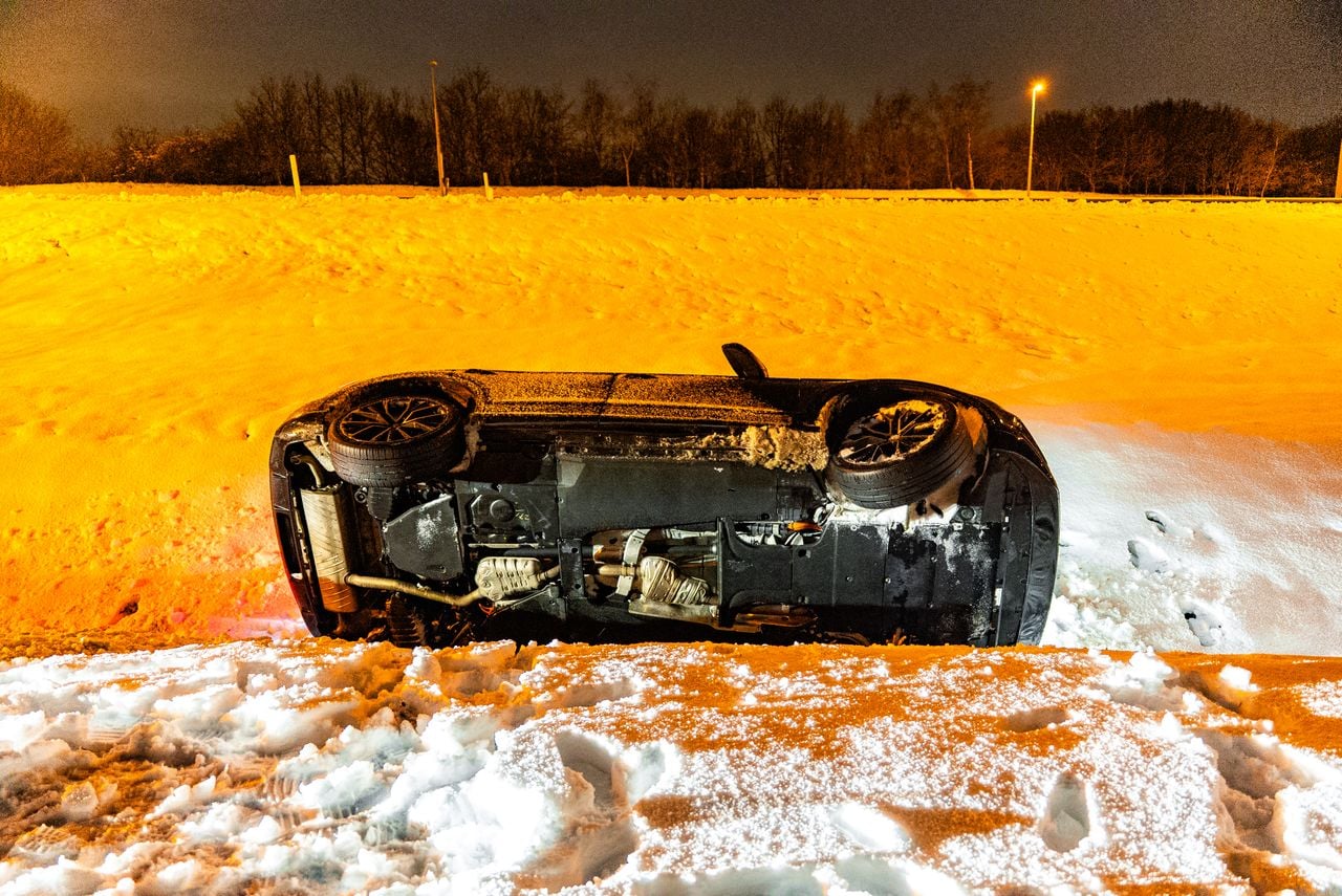 Een auto gleed in Oss van de weg en kwam in de sloot tot stilstand (foto: Lucas Lammers/Persbureau Heitink).
