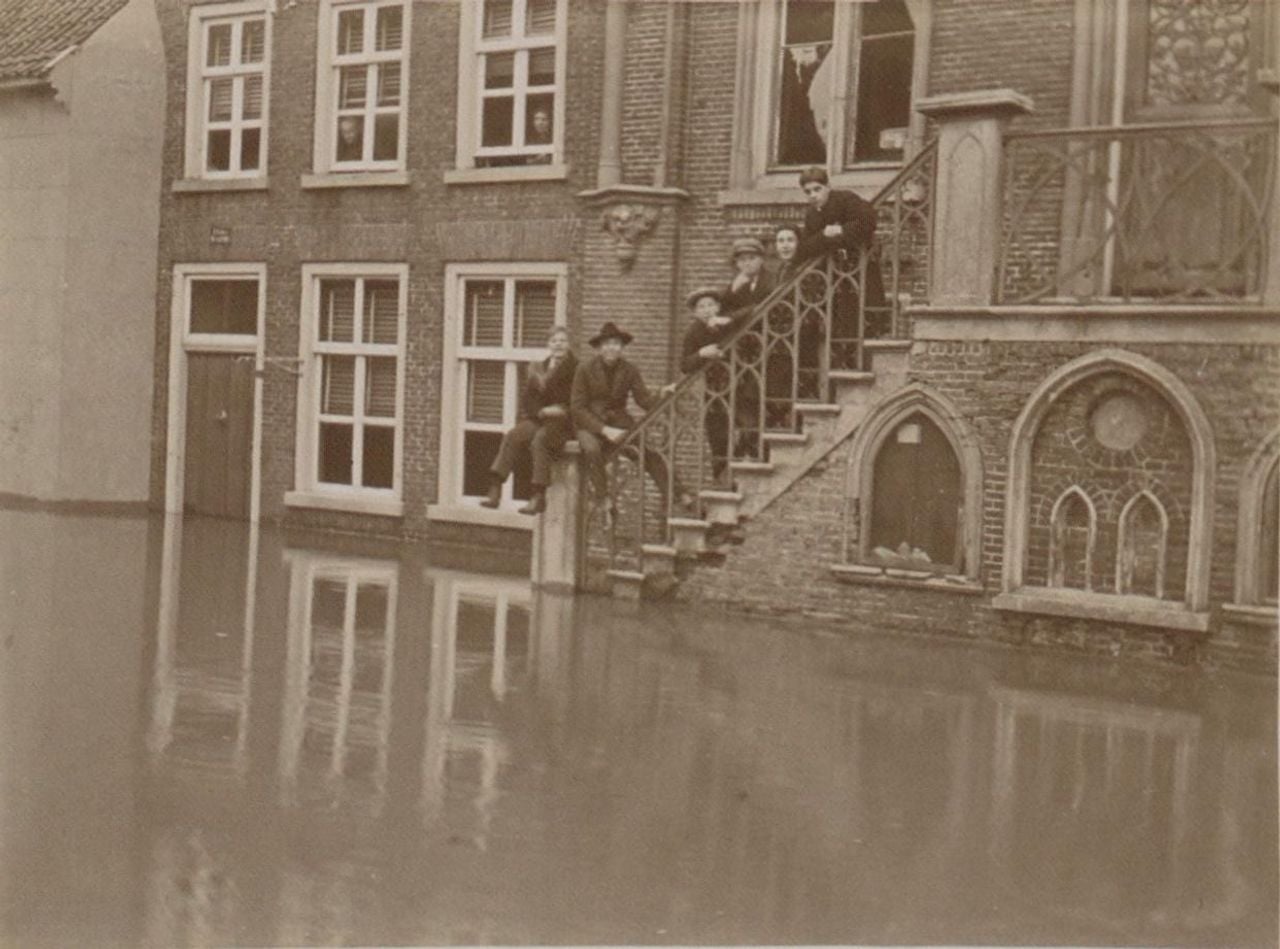 Mensen staan op het bordes van het gemeentehuis in Cuijk als de straten zijn ondergelopen
