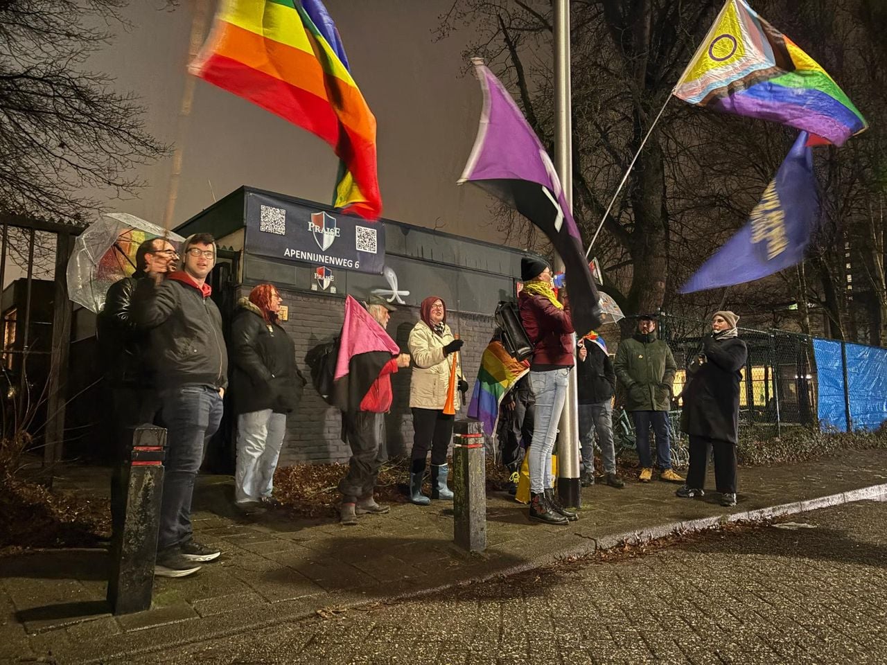 Demonstranten zwaaien met vlaggen voor de ingang van de kerk.