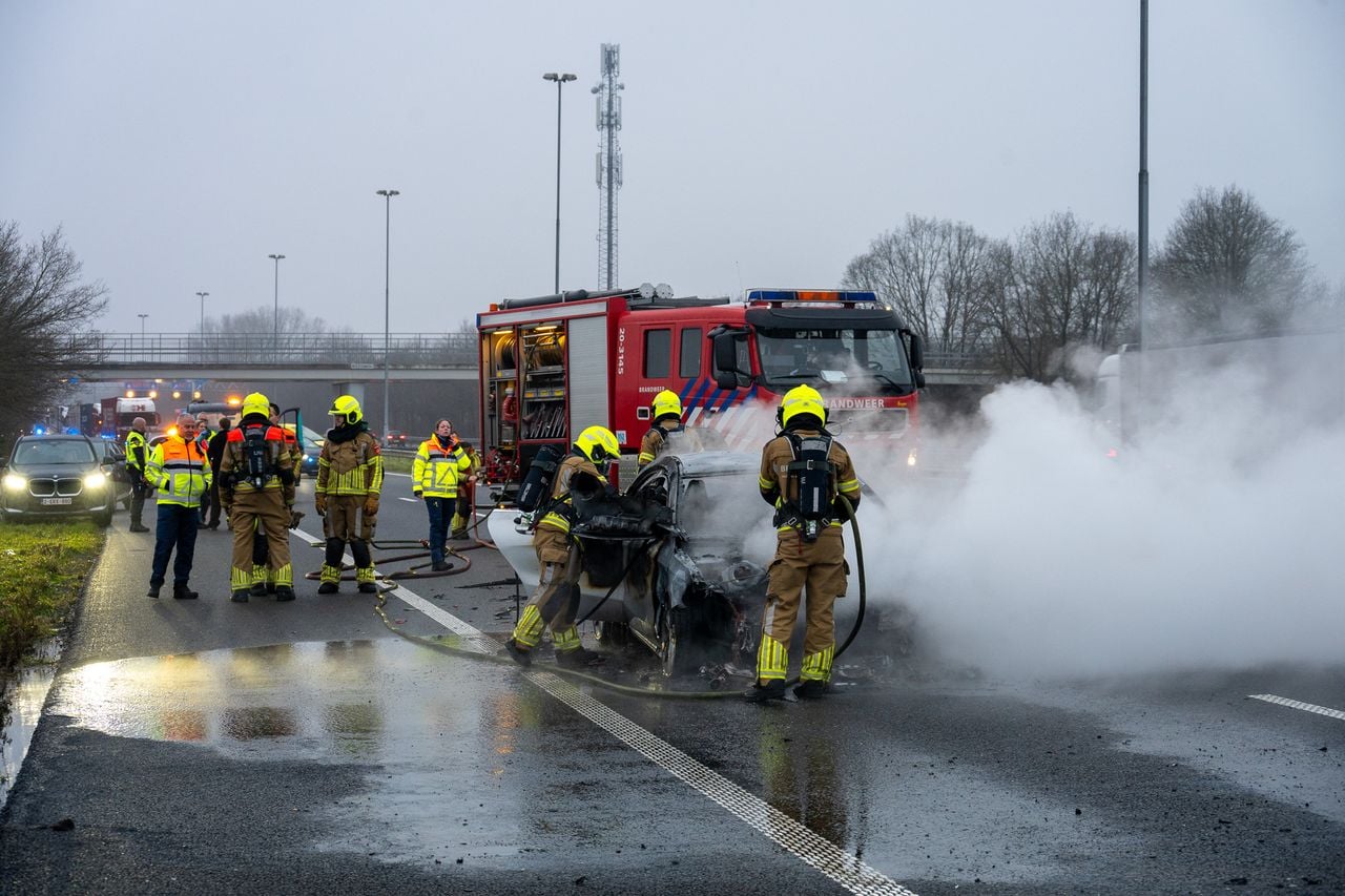 Een personenauto vloog na het ongeluk met twee vrachtwagens in brand (foto: Tom van der Put/Persbureau Heitink).