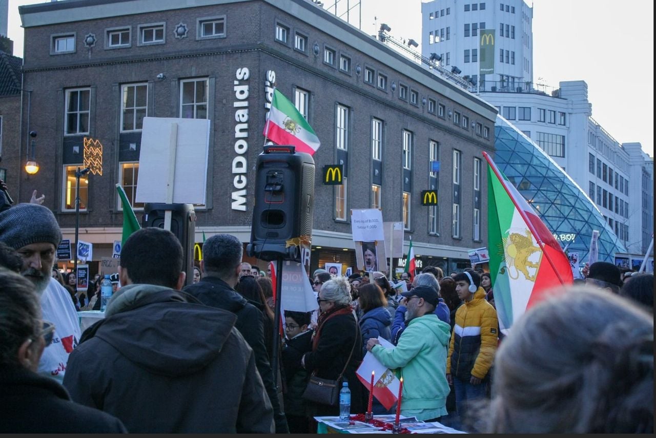 Protestborden en vlaggen van voor de Iraanse revolutie waren te zien op het plein (Foto: Timo ter Haar.)