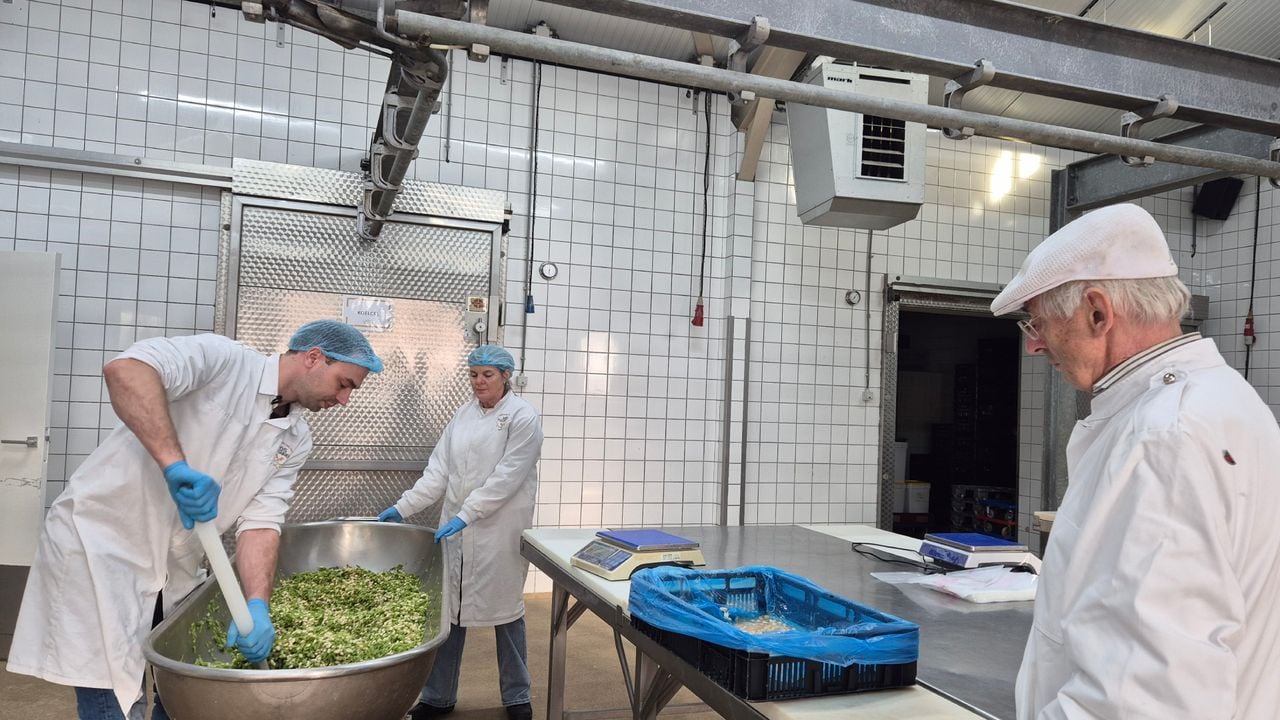 Onder toeziend oog van voormalig slager Kees Janson, mengt slager Geert-Jan Vos (links) de 'gruune' bonen met de witte (foto: Niek de Bruijn)