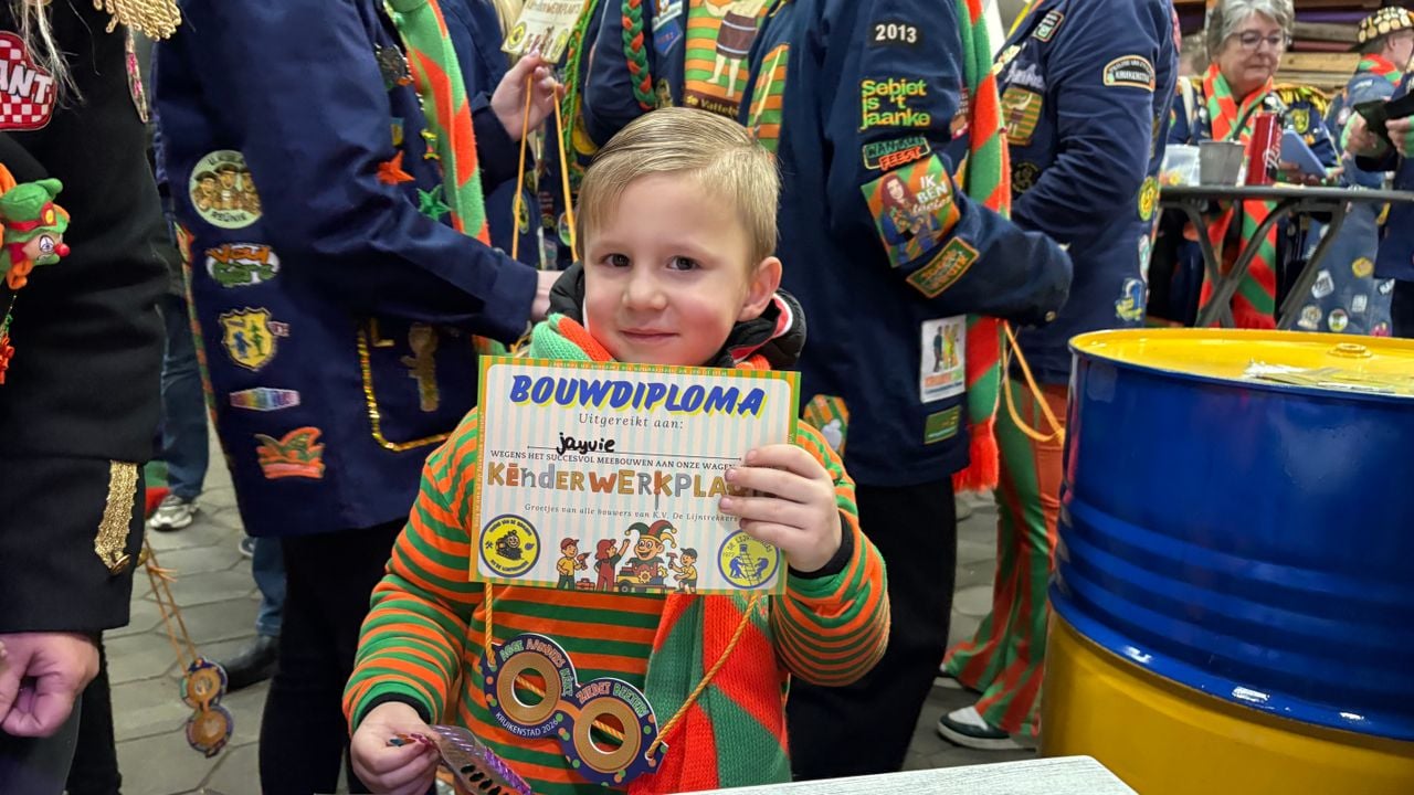 Jayvie laat trots zijn bouwdiploma zien.