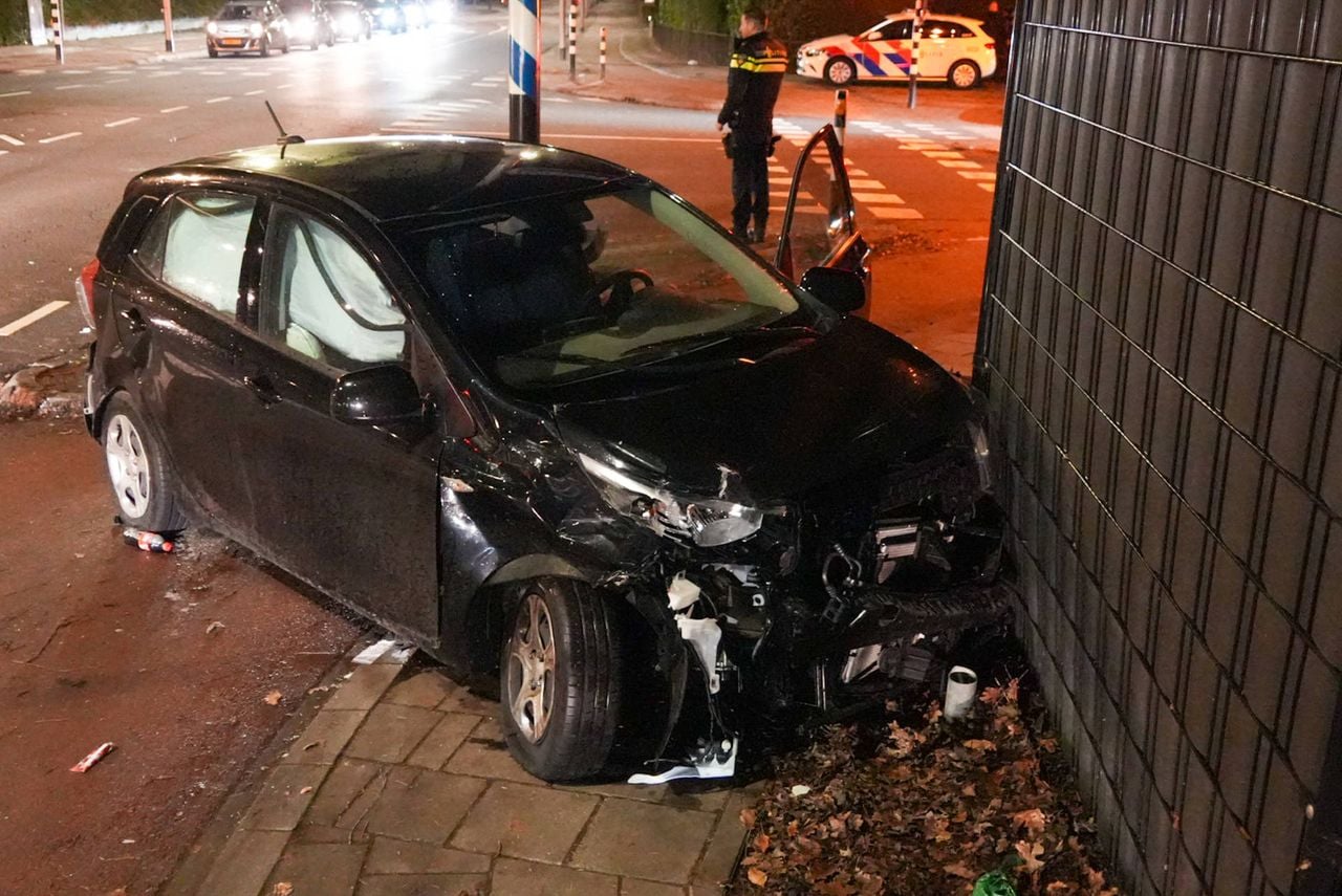 De auto kwam tot stilstand tegen een hek op het kruispunt in Helmond (foto: Harrie Grijseels/Persbureau Heitink).