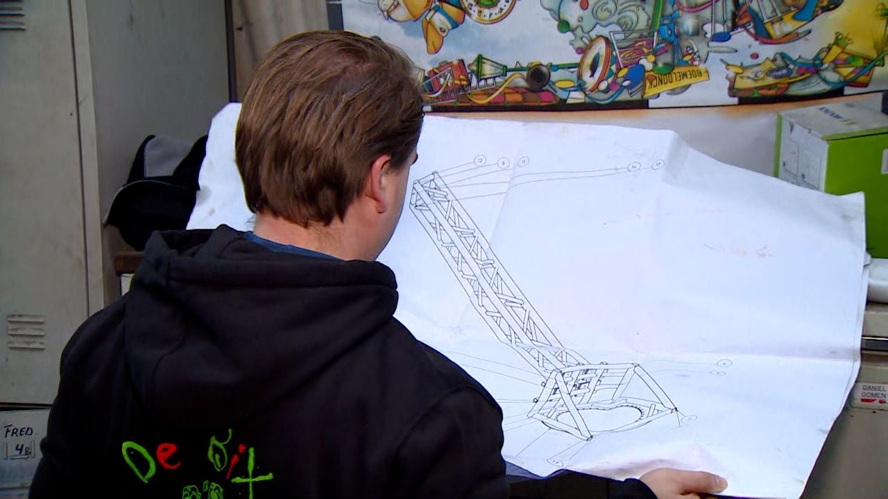 Michiel laat een van de bouwtekeningen zien van CV De Bixe Draoke (foto: Omroep Brabant).