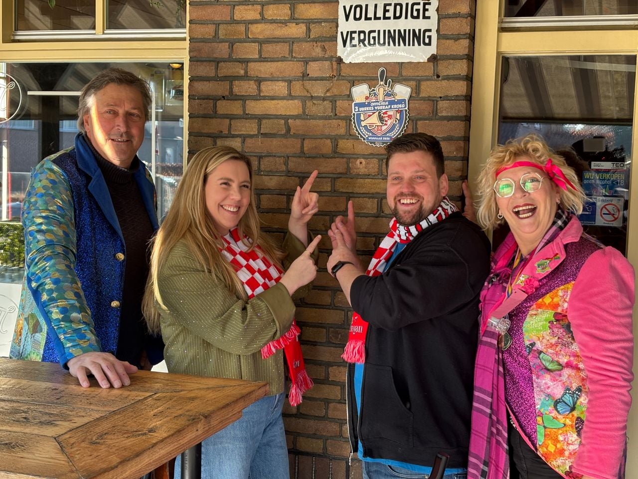 Leden van de Predbant (links en rechts) en uitbaters Stephanie en Roel bij de speciale plaquette (foto: Omroep Brabant).