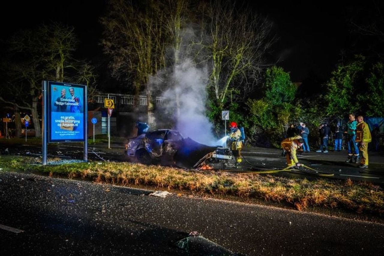 De brandweer bluste de auto na de crash in Eindhoven (foto: Persbureau Heitink).