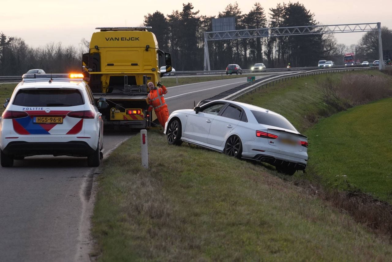 Auto belandt onderaan talud bij oprit A67 bij Lierop (foto: Harrie Grijseels / Persbureau Heitink).