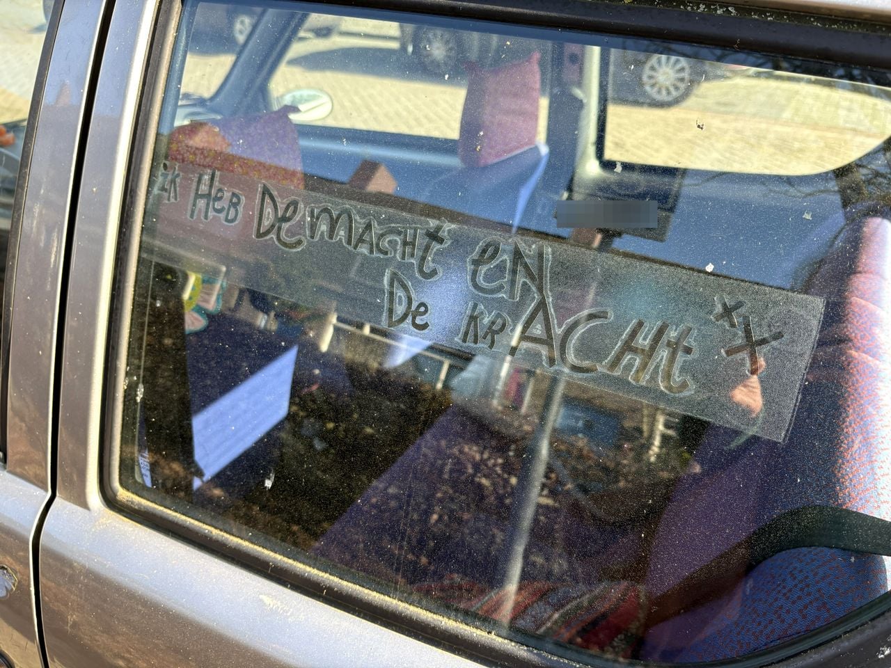 Een persoonlijke spreuk op de ruit van haar autootje (foto: Karin Kamp)