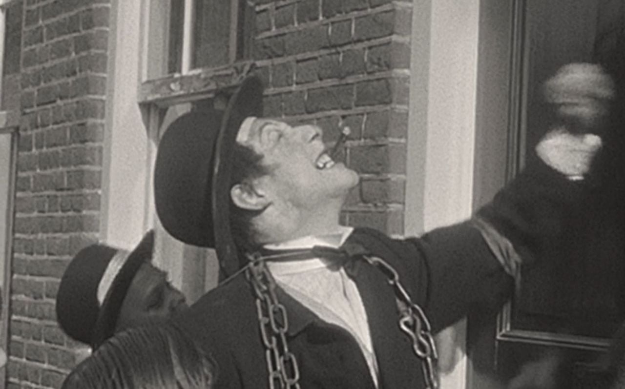 'NSB-burgemeester Schregardus' bonst op een deur tijdens een 'razzia' in Waalre (foto:  Bernard van Dooren/BHIC)