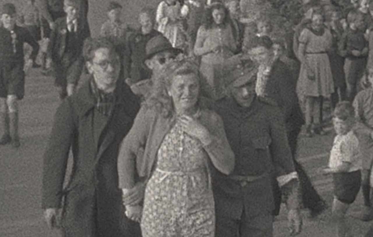 Een vrouw wordt in Waalre lachend afgevoerd door 'Duitse soldaten en NSB'ers' (Bernard van Dooren/BHIC)