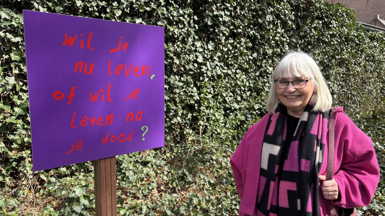 Weduwe Gerry Diederen staat bij een van de borden met een spreuk van haar overleden man Arnol Kox die vrijdag een eigen pad kreeg (foto: Wilco Zonneveld).