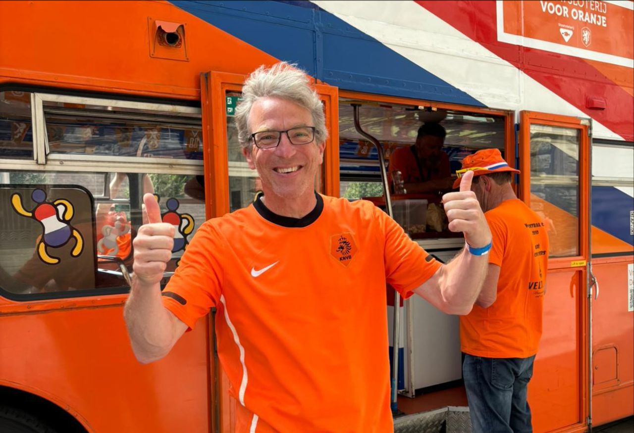 Sjoerd van Fessem bij de oranje dubbeldekker.