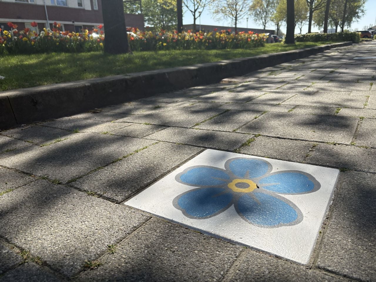 Stoeptegels met vergeet-me-nietjes geven de route aan (foto: Karin Kamp).
