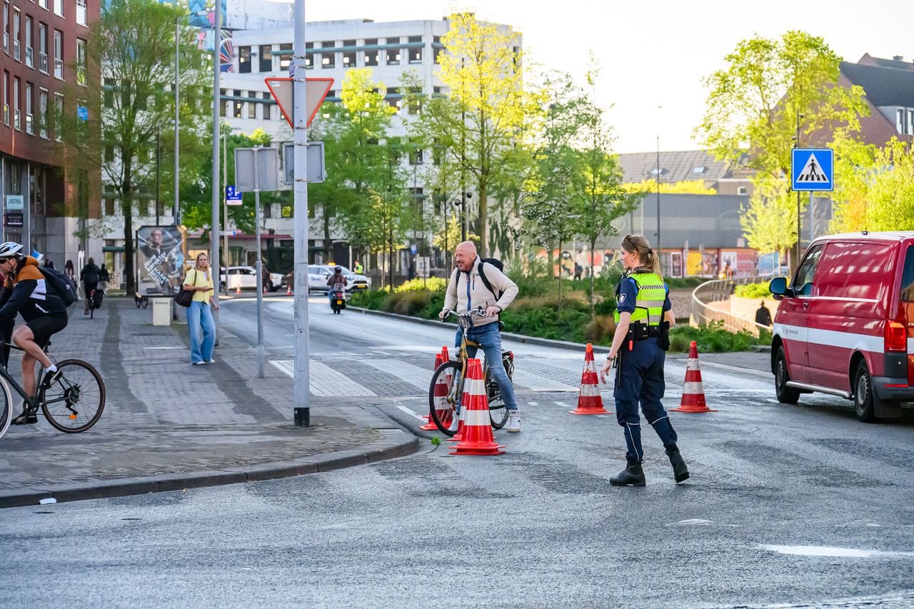 De handhaving wijst voorbijkomende fietsers op het spekgladde oliespoor. (Foto: Tom van der Put / Persbureau Heitink.)
