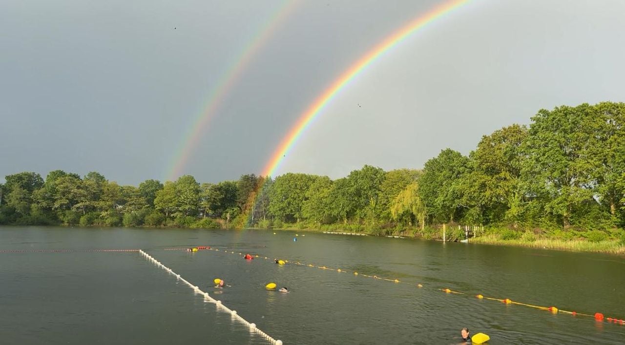 Zodra de zwemmers het water ingaan, verschijnt er een dubbele regenboog (foto: Pieter Soethout)