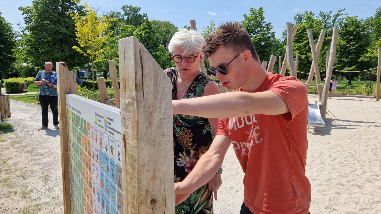 Luc samen met zijn moeder bij het communicatiebord in de speeltuin van Streekpark Kienehoef in Sint-Oedenrode (foto: Tom Berkers).