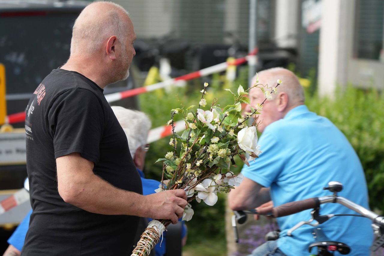 Buurtbewoners leggen bloemen neer in de buurt van het huis (foto: Jeroen Stuve / Persbureau Heitink).