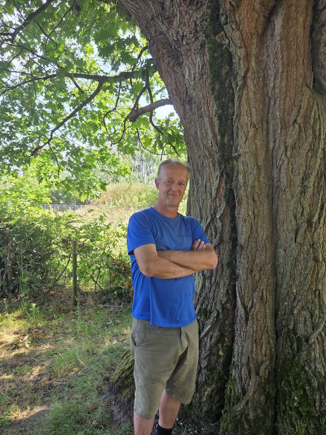 Johan Hoving op zijn favoriete plek op de begraafplaats in Sprang-Capelle, bij een eeuwenoude Amerikaanse eik (foto: Henk van Ingen/Omroep Brabant).