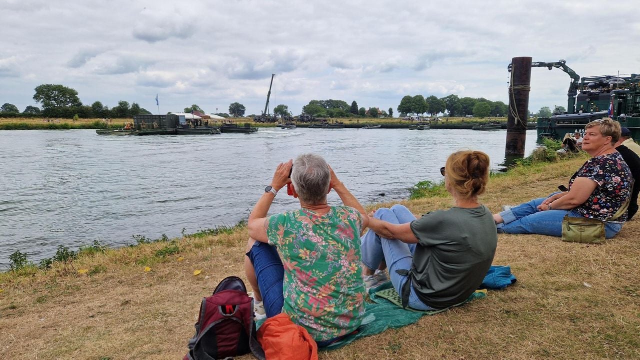 Veel mensen blijven kijken hoe de militairen van Regiment Genietroepen de pontonbrug weghalen.