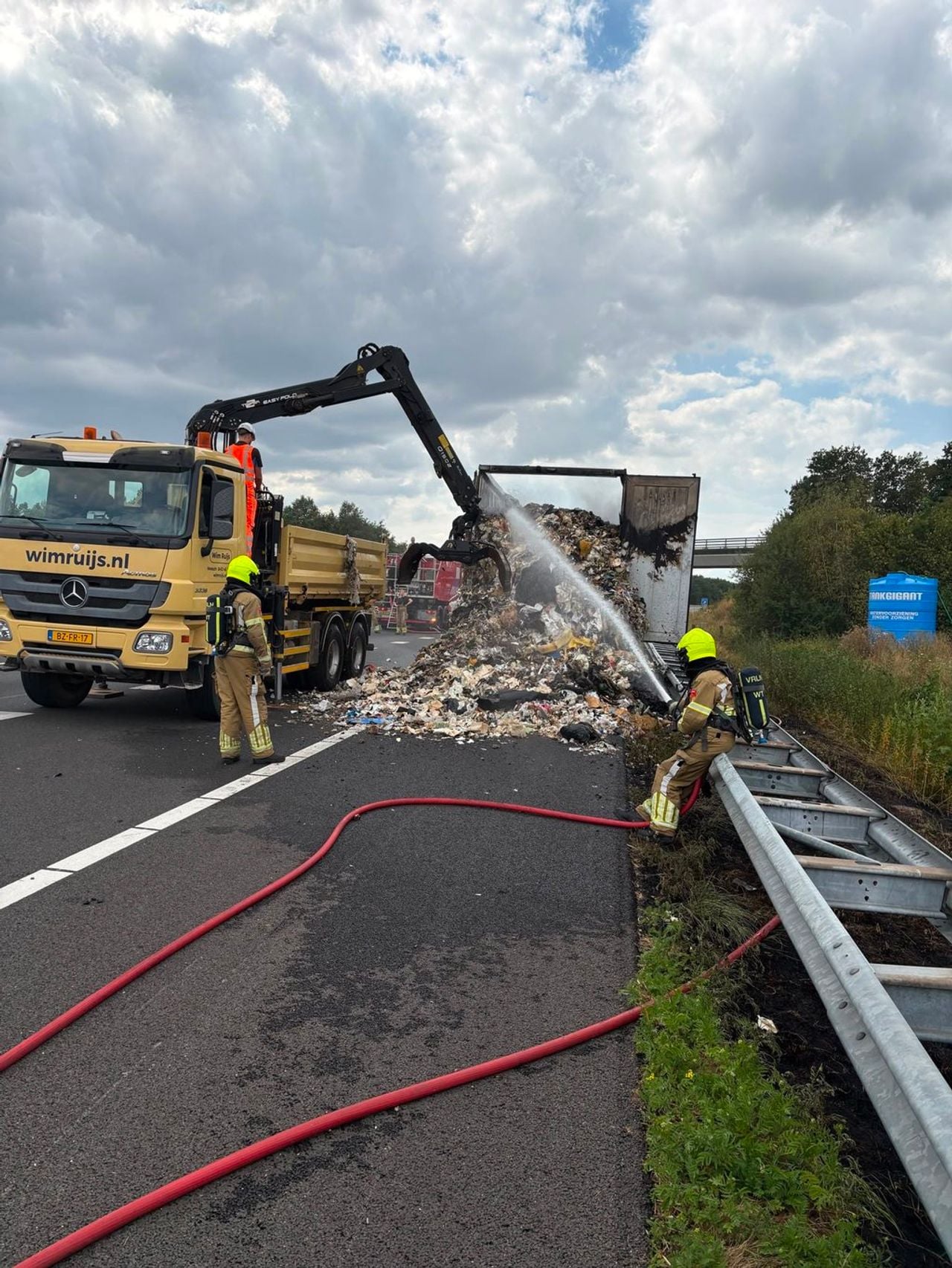 Het afval is uit de vrachtwagen gehaald en wordt geblust (foto: Rijkswaterstaat).