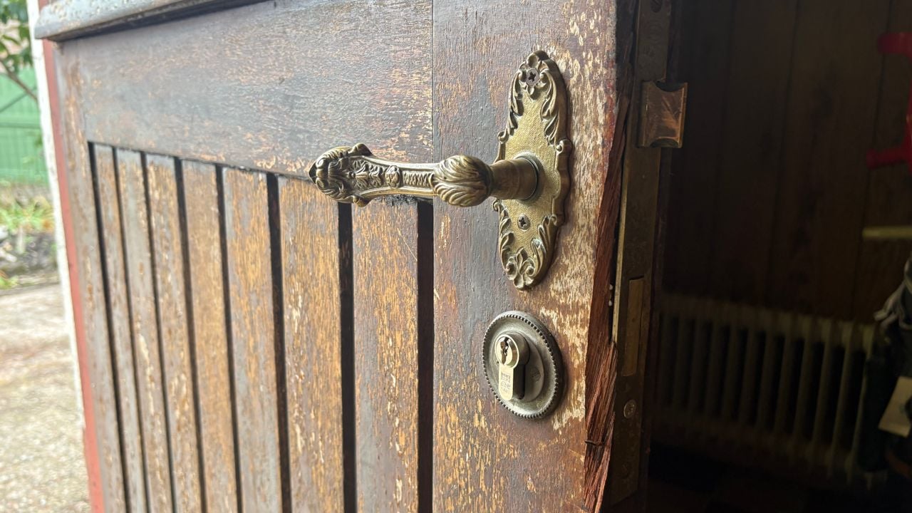 De beschadigde deur na de inval door de politie