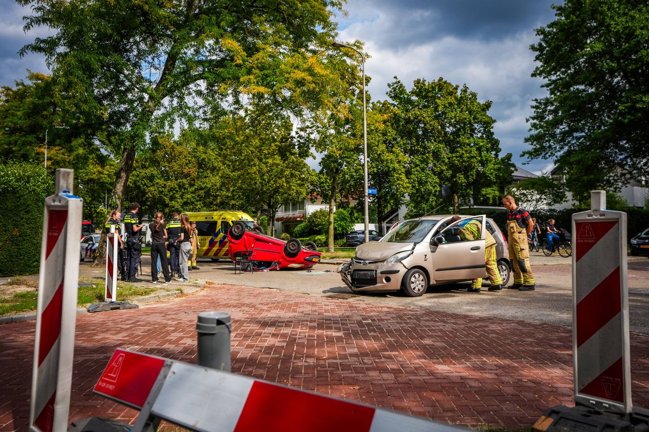 Auto over de kop bij botsing op kruising in Eindhoven (foto: Persbureau Heitink).