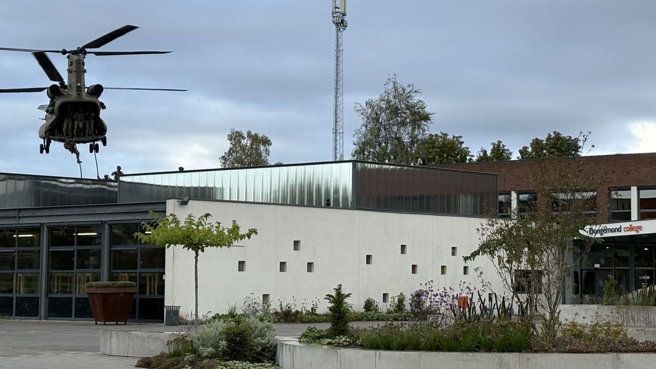 Gewapende militairen glijden via een touw het dak van de school op (foto: Wilco Zonneveld).