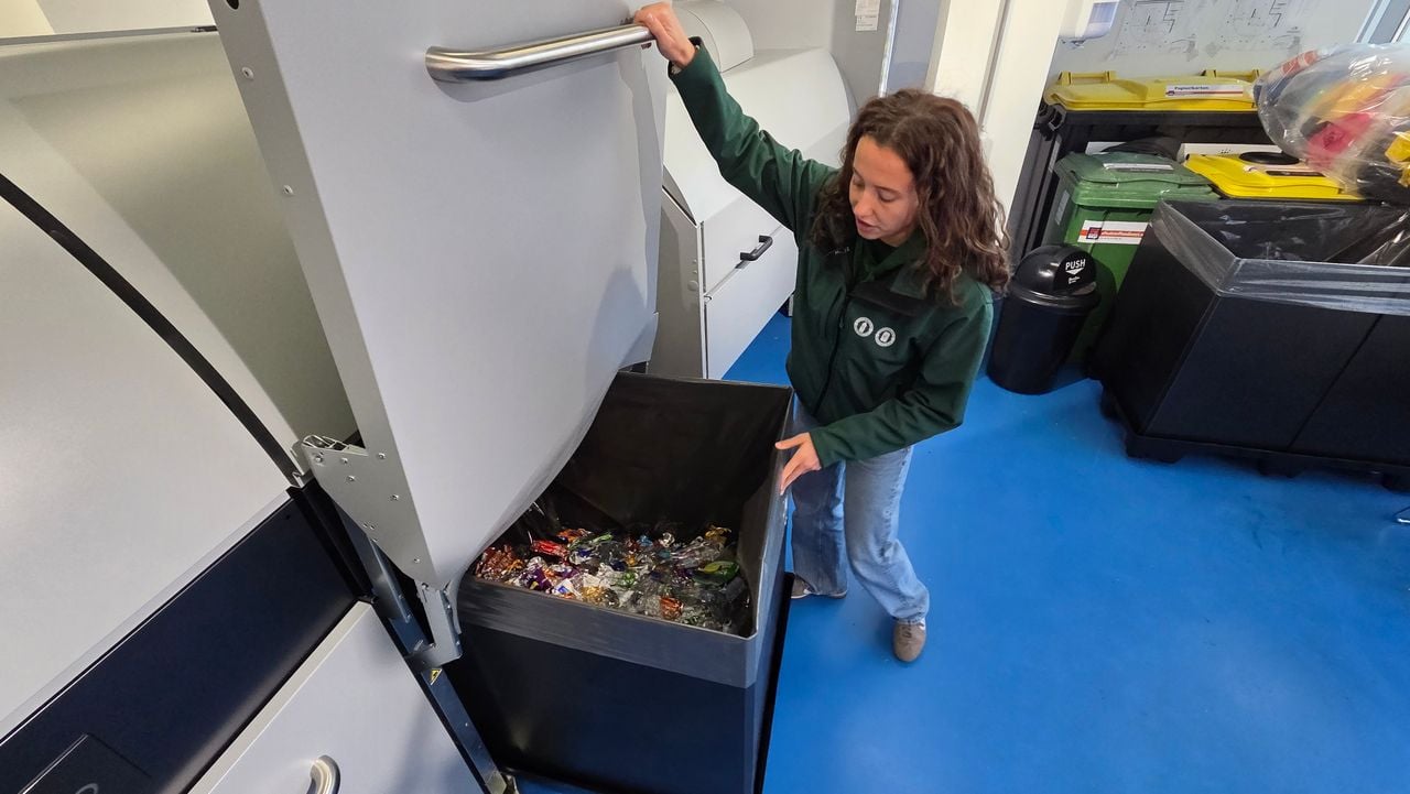 Medewerker Willemijn Bal van de retourshop laat zien hoe de ingeleverde flessen geplet en opgevangen worden (foto: Noël van Hooft).